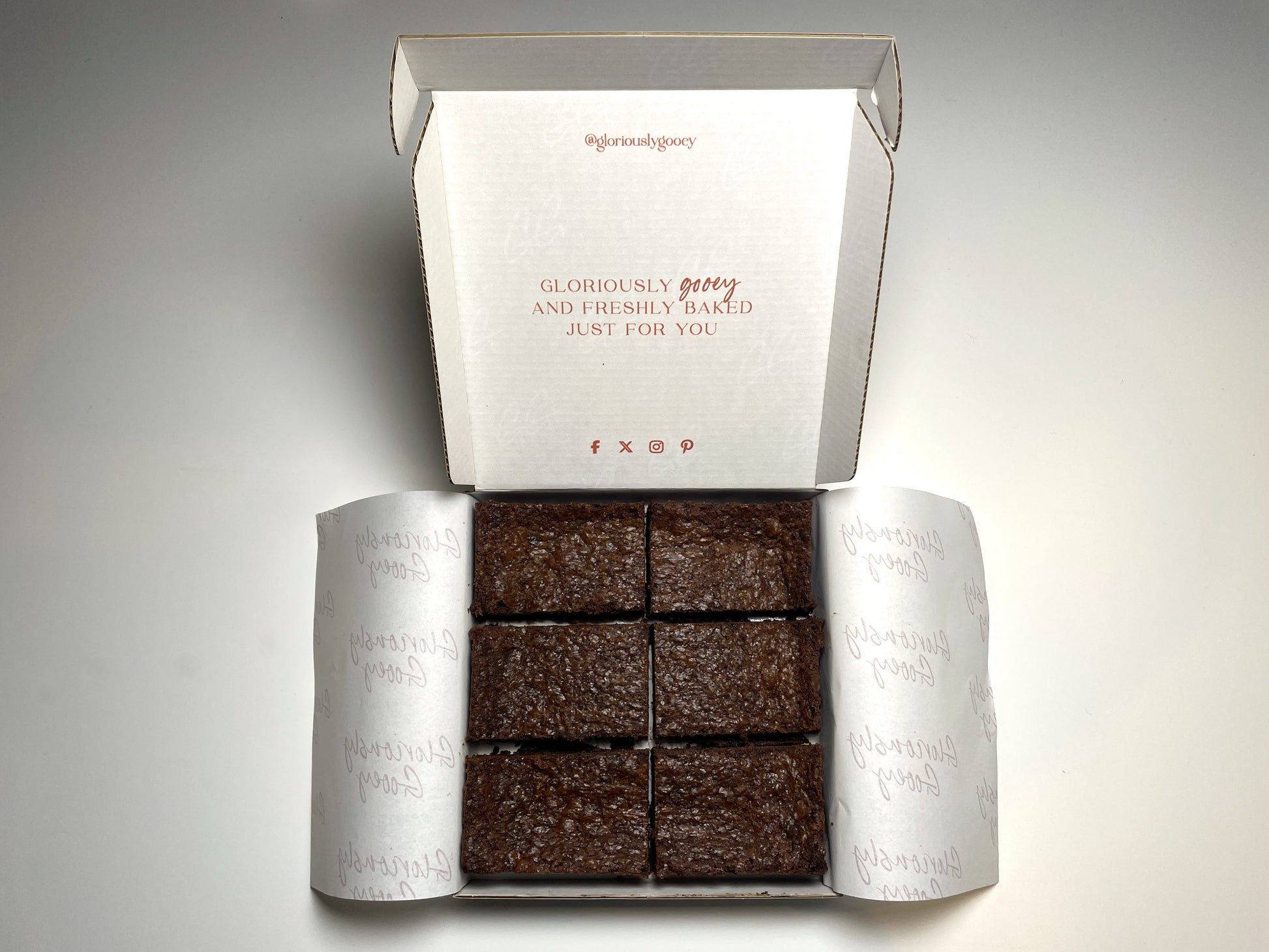 Open brownie box filled with Gloriously Gooey brownies, showcasing the ultimate chocolate indulgence